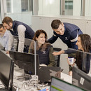 Five peoples in an office speaking with Premiere Couriers hoodies